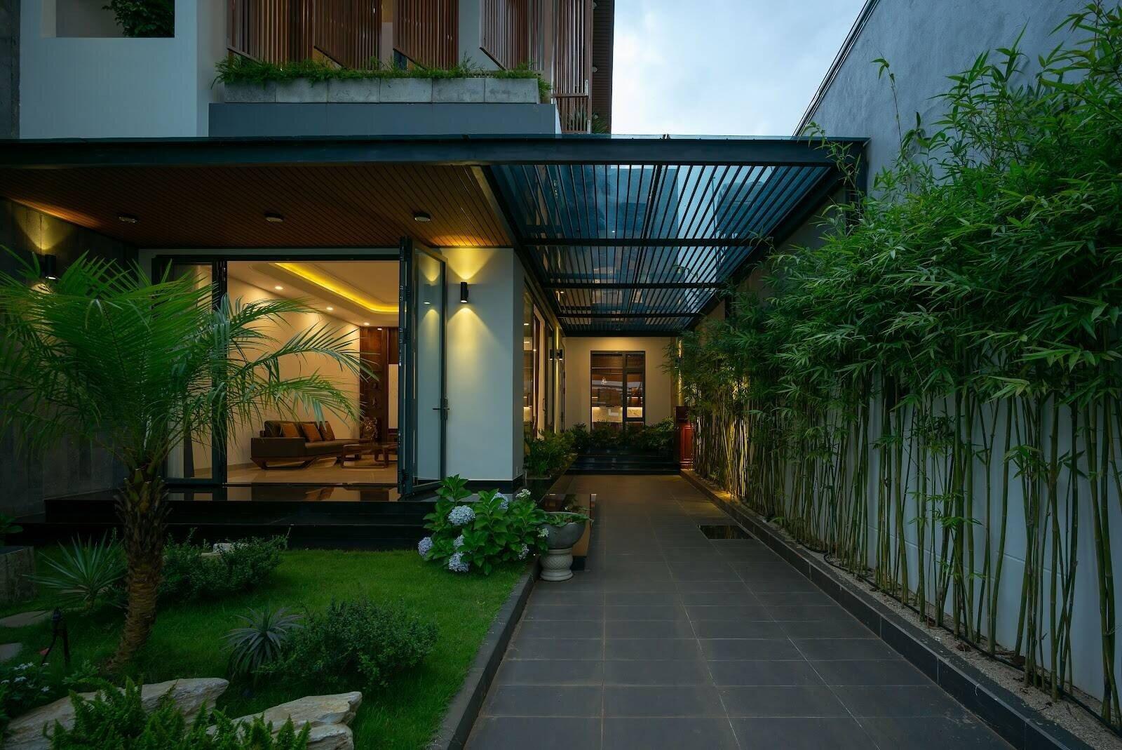 Lối đi bên hông nhà cấp 4 thiết kế hiện đại có mái che và hàng trúc dọc tường (Nguồn: Internet)